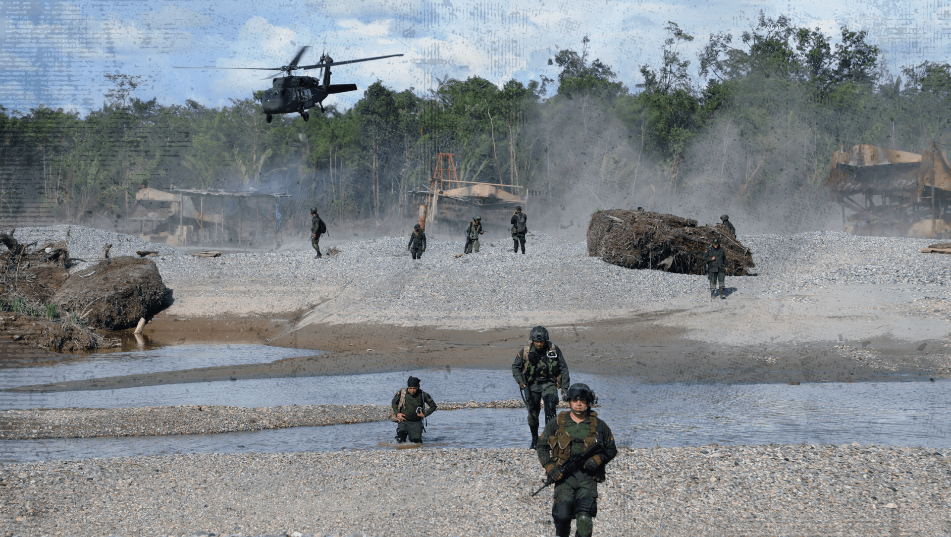 Militares armados avanzan por un lecho de río junto a maquinaria de minería ilegal, mientras un helicóptero sobrevuela la zona, durante una operación en un entorno selvático.